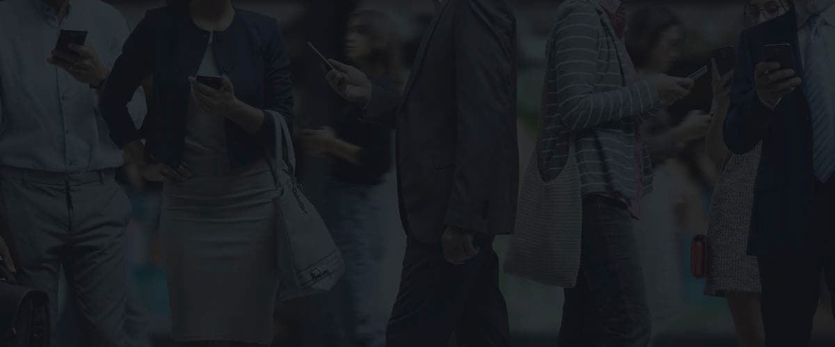 People standing in a crowd, each looking at a smartphone