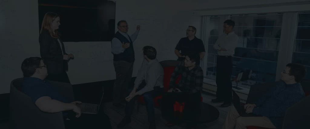 Vail Research team collaborating in a lab with a whiteboard behind them